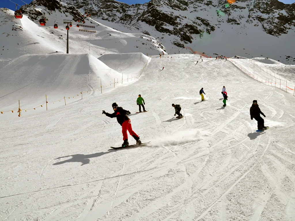 Mehrere Snowboardende auf dem weiten Hang.